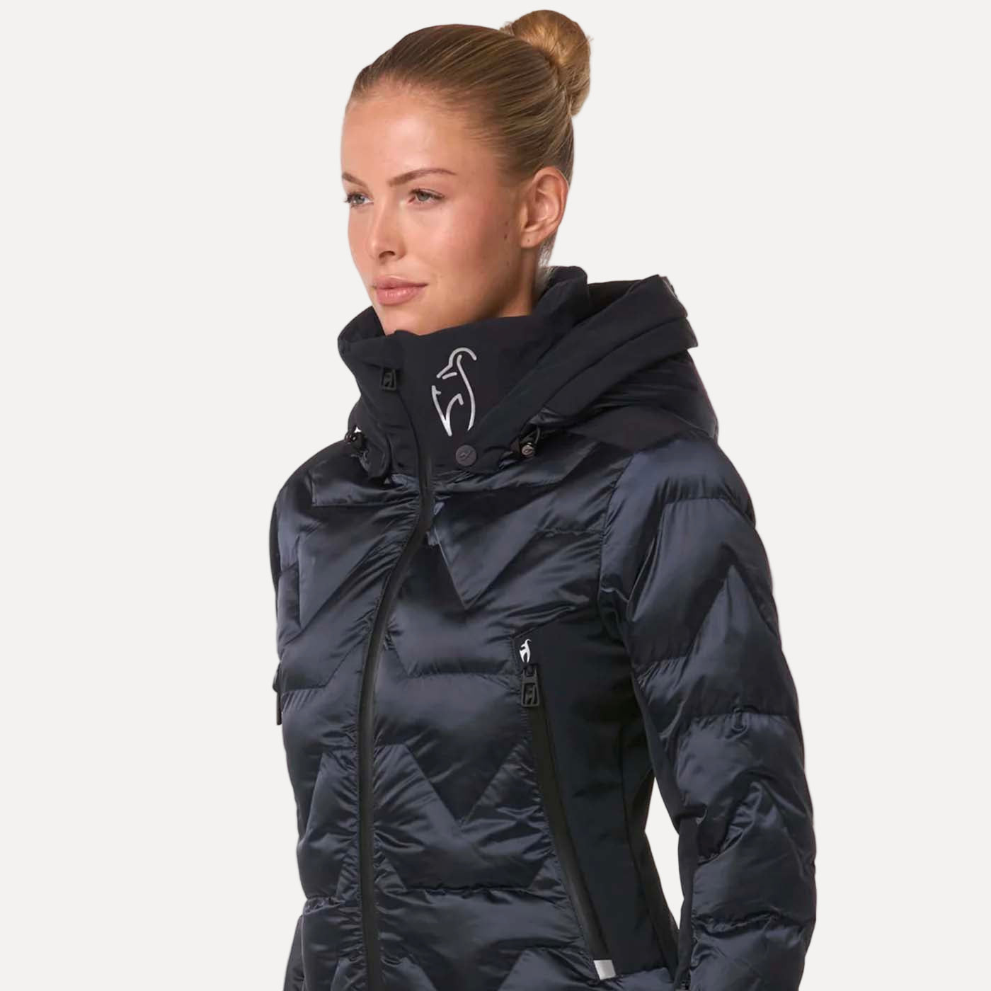 Woman wearing a dark blue winter jacket with a hood on a white background